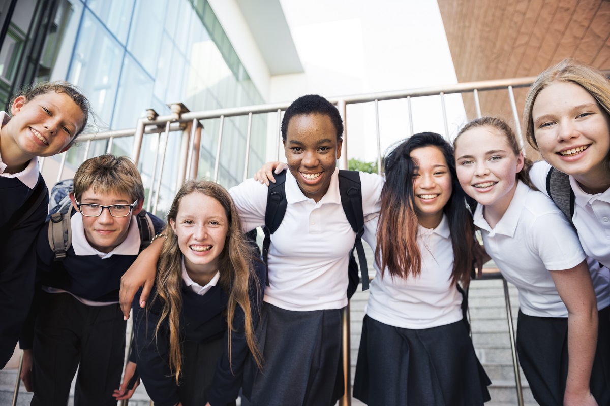 smiling high school students  at their school's hallway