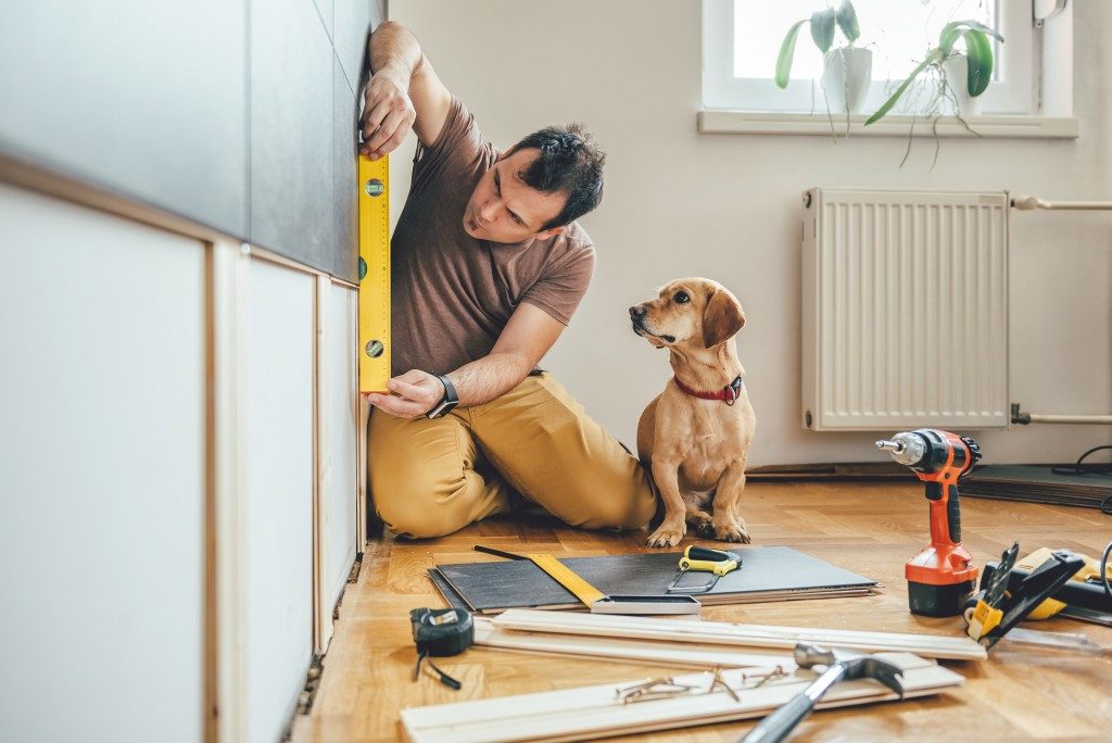 man fixing the house with his dog