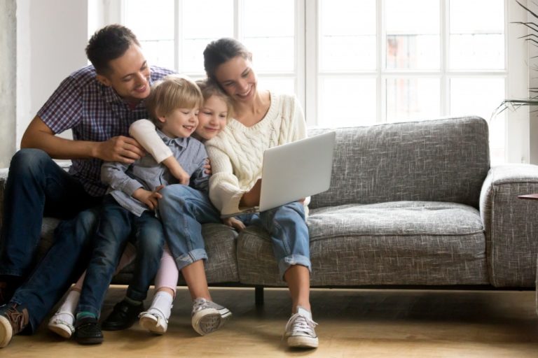family of three watching on laptop