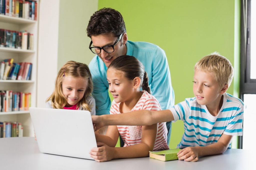 man using laptop with his kids