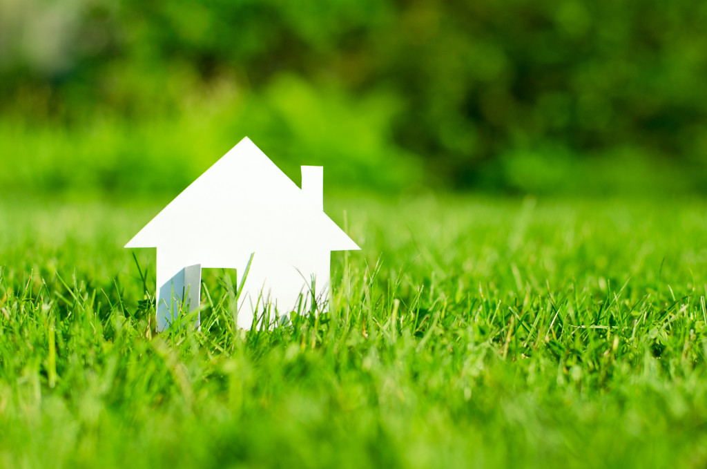 property investment represented by paper house in a grass field